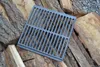 A cast iron grate is placed on a pile of firewood. Anteprima dell’immagine prodotto