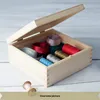 A wooden box filled with spools of ribbon and thread. Produktbild-Vorschau