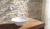 A modern bathroom sink with a wall-mounted faucet against a stone tile wall. Náhľad obrázku produktu