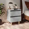 A bedside table with a lamp and a book next to a bed. Anteprima dell’immagine prodotto