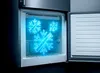 The interior of an open refrigerator or freezer with glowing blue snowflake icons. Produktbild-Vorschau