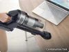 A hand is holding a vacuum cleaner and cleaning a wooden desk next to a laptop. Náhled obrázku produktu