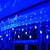 Blue star-shaped string lights hanging in front of a window. Náhled obrázku produktu