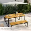 An outdoor dining set with a table and benches under a large umbrella, set on a patio. Produktbild-Vorschau