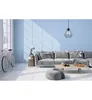 A modern living room with a light blue wall, a gray sectional sofa, a coffee table, and a pink bicycle. Produktbild-Vorschau