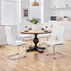 A dining set with a round wooden table and four white chairs in a bright, modern kitchen. Podgląd zdjęcia produktu