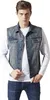 A man wearing a denim vest over a white long-sleeved shirt and blue jeans. Produktbild-Vorschau