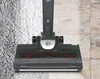 A vacuum cleaner head is shown cleaning a carpet and tile floor. Produktbild-Vorschau