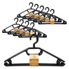 A stack of black plastic clothes hangers with a yellow and brown label. Produktbild-Vorschau