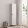 A tall, white metal locker stands next to a window with sheer curtains and a plant. A wire basket with blankets is on the left. Produktbild-Vorschau