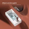 A close-up view of a white ceramic sink with water swirling down the drain, with a chrome faucet. The background is a warm brown color, and a reflection of the sink and faucet is visible in a mirror above. Voir les images du produit