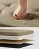 A hand pressing down on a cushioned surface of a bench, with a layered diagram of the bench's construction below. Náhled obrázku produktu