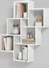 A white, multi-compartment wall shelf unit displaying books and decorative items. Produktbild-Vorschau