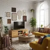 A cozy living room with a TV, sofa, coffee table, and decorative items. Produktbild-Vorschau