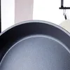 Close-up view of the rim and interior of a dark-colored frying pan. Produktbild-Vorschau