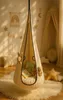 A cozy nursery or child's room with a hanging pod chair, decorated with celestial-themed wall hangings and soft furnishings. Produktbild-Vorschau