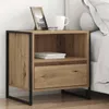 A wooden nightstand with a black metal frame is placed next to a bed. Produktbild-Vorschau
