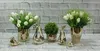 A collection of decorative items including vases with artificial flowers, ceramic pear sculptures, and small bird figurines, arranged on a white brick surface. Anteprima dell’immagine prodotto