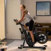 Frau trainiert auf Matrix ICR50 Indoor Cycle in einer Wohnzimmerumgebung Produktbild-Vorschau