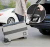 A person is loading a portable cooler into the trunk of a car. Produktbild-Vorschau