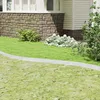 A garden scene with a stone wall, grass, and plants, featuring a metal garden edging. Produktbild-Vorschau