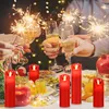 A group of people are celebrating with champagne and sparklers, with red LED candles and food on a table. Produktbild-Vorschau