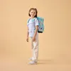 A young girl stands facing the camera, wearing a backpack. Náhľad obrázku produktu