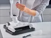 A person's hands are holding a cleaning brush and inserting it into a vacuum cleaner head. Produktbild-Vorschau