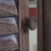 A close-up view of a wooden door handle and shutter. Podgląd zdjęcia produktu