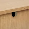 A close-up view of the edge of a wooden furniture piece, showing a metal bracket attached to the underside of the top surface. Podgląd zdjęcia produktu