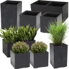 A collection of dark gray concrete planters of various sizes and shapes, some containing plants. Produktbild-Vorschau