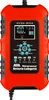 A red and black battery charger with a digital display and control buttons. Voir les images du produit