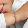 A close-up shot of a person's arm wearing a rose gold bracelet with a heart-shaped charm. Podgląd zdjęcia produktu