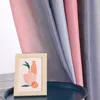 A framed picture of abstract art sits on a dark blue table in front of a gradient curtain. Produktbild-Vorschau