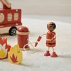 A wooden toy firefighter set including a fire truck, a firefighter figure, flames, and a hydrant. Produktbild-Vorschau