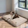 A dog is lying on a beige dog bed in a room with wooden floors and a window. Náhľad obrázku produktu