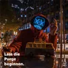 A person wearing a glowing blue LED mask sits in front of a city skyline at night, holding a toy van. Produktbild-Vorschau