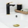 A close-up view of a modern bathroom sink with a black and gold faucet. Náhled obrázku produktu