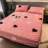 A bed with pink bedding featuring heart patterns. Náhled obrázku produktu