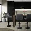 A modern kitchen or dining area with bar stools around a counter. Voir les images du produit