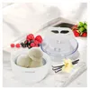 An ice cream maker with a bowl of ice cream and berries on a marble countertop. Náhľad obrázku produktu