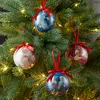 Christmas tree ornaments hanging on a decorated Christmas tree. Produktbild-Vorschau