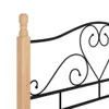 A close-up view of a black metal bed frame with a wooden post. Produktbild-Vorschau