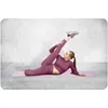 A woman is performing a stretching exercise on a yoga mat. Anteprima dell’immagine prodotto