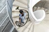 A person is vacuuming a spiral staircase. Produktbild-Vorschau
