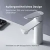A modern white faucet with a gray top is displayed on a white surface, with a smartphone partially visible on the left. Produktbild-Vorschau