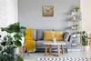 A living room scene with a sofa, clock, and plants. Náhled obrázku produktu