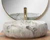 A marble basin with a gold faucet is shown in front of a mirror. Anteprima dell’immagine prodotto