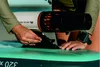 A person is attaching an Aqua Marina BlueDrive X PRO Power Fin to a paddleboard. Podgląd zdjęcia produktu