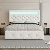 A white upholstered bed with a tufted headboard and footboard, featuring integrated LED lighting, is shown in a bedroom setting. Produktbild-Vorschau